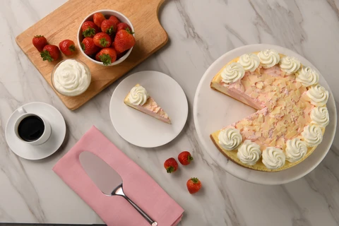 Wild Strawberries and Cream cheesecake with a plated slice and coffee